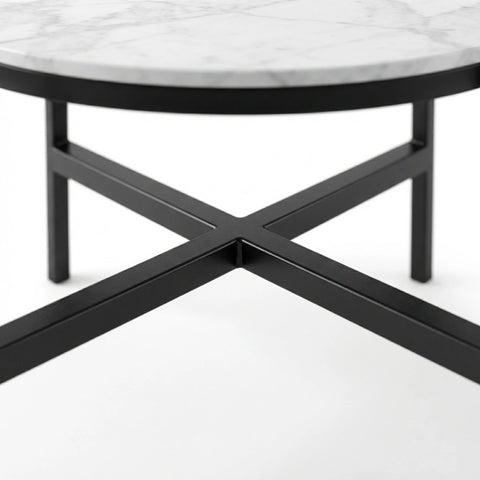 Close-up of a round coffee table with a white marble top and a black metal X-shaped base on a white background.