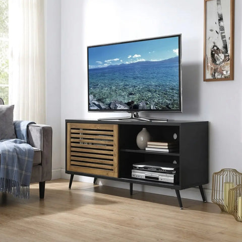 Modern living room with a black and wood TV stand displaying a nature scene on a television.