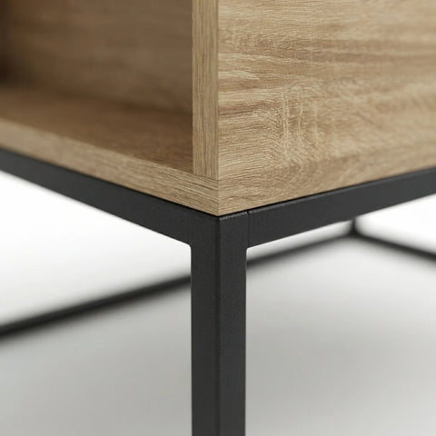 Close-up of a modern table corner showing a light oak wood grain top and shelf with a matte black metal frame and leg.